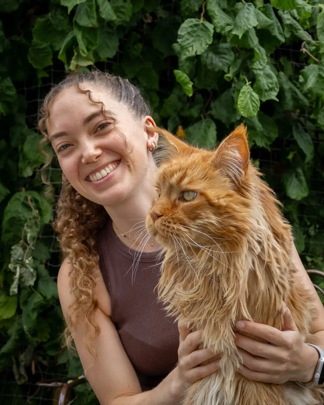Maya Arnould tenant un chat roux dans les bras